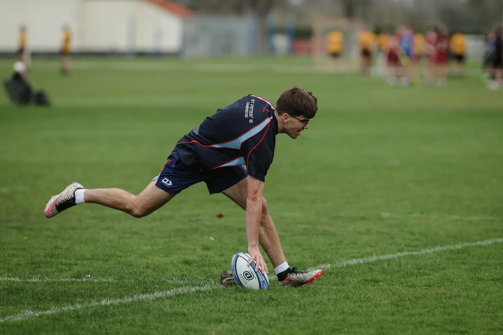 Jugador apoyando la pelota en un ejercicio de rugby